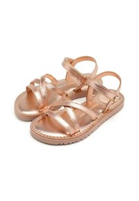 Sandalias planas color oro rosa con múltiples tiras entrelazadas, un acabado metálico suave y una suela texturizada para un mejor agarre. Diseño ligero y flexible.