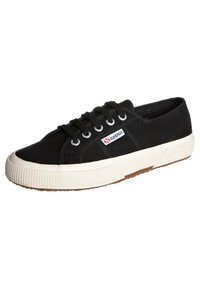 Sneaker nera in tela con punta tonda, suola in gomma bianca e dettagli testurizzati. Presenta sei fori per i lacci e una patch con il logo sul lato.