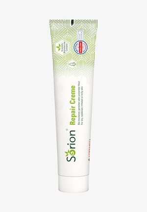 Sörion Reparaturcreme-Tube, weiß mit grünen Akzenten, verfügt über ein sechseckiges Muster, einen Schraubverschluss und Etiketten, die die Hautverträglichkeit und Zertifizierung anzeigen.