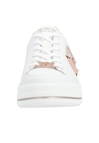 Hvid sneaker med en struktureret overflade, der har roséguld hardware, snørebånd og en diskret hæjhævning. Enkel, moderne design.