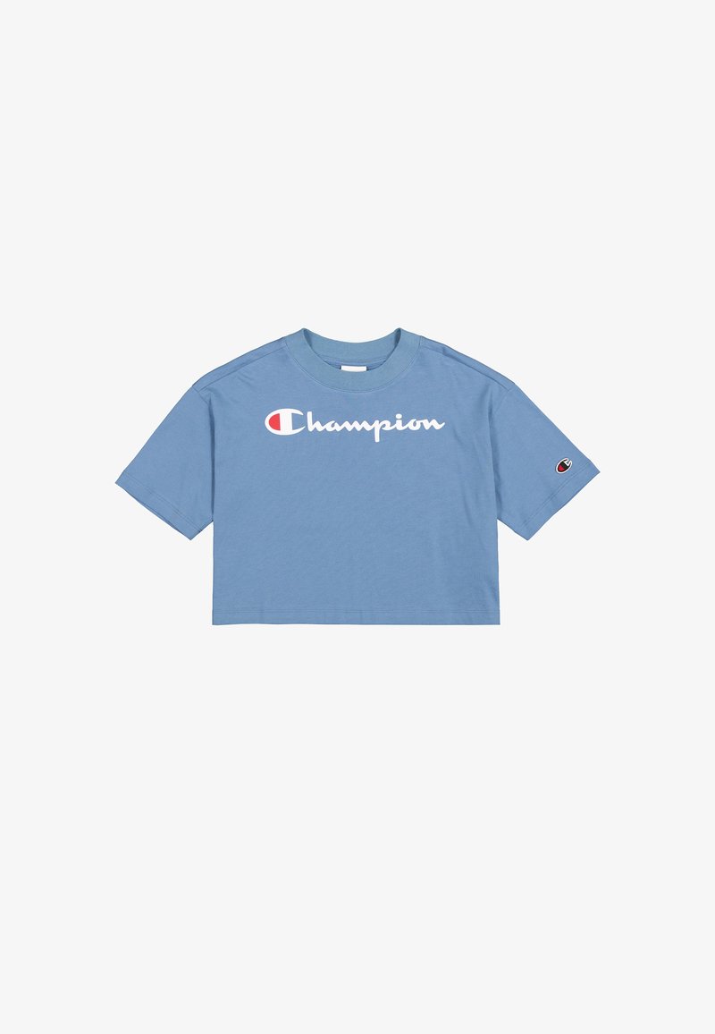Camiseta azul recortada de algodón, con un logotipo blanco de "Champion" en la parte frontal y un pequeño logotipo en la manga izquierda.