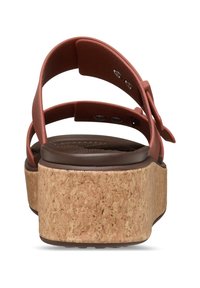 Brown cork platform sandal with red synthetic straps, featuring a textured upper and adjustable buckle. Thick sole for added height.