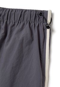 Grijze sportieve shorts van een gestructureerd, lichtgewicht materiaal met een elastische tailleband en een contrasterende witte zijstreep en trekkoord.
