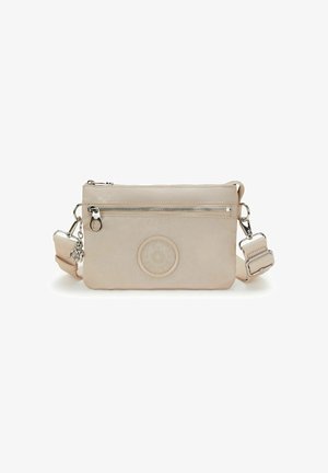 Beige crossbody bag with front zip pocket, adjustable strap, round embossed logo, and small keychain charm attached to zipper.