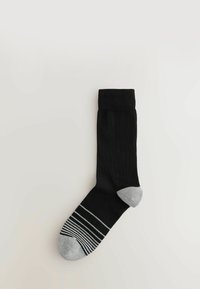 Sosete negre din bumbac cu o mansetă ribbată. Prezintă un vârf gri cu dungi orizontale, în contrast cu culoarea solidă a corpului.