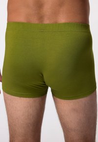 Boxers en olive vert fabriqués à partir d'un tissu doux et extensible avec une texture lisse et une ceinture élastique confortable.