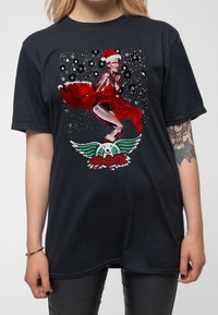 Black cotton t-shirt featuring a graphic design of a figure in a red dress and Santa hat, with Aerosmith text and winged logo.