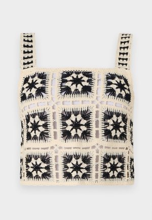 Häkel-Crop-Top mit einer cremfarbenen Basis, schwarzer floraler Stickerei, quadratischen Motiven und verstellbaren Trägern. Das offene Gewebedesign verleiht Textur.