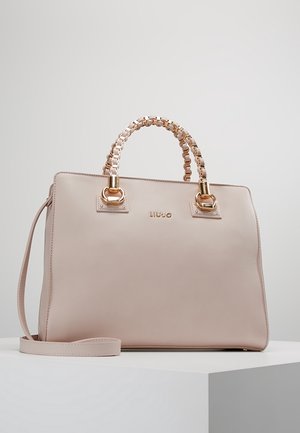 Sac à main beige Liu Jo avec des poignées en chaîne dorée et une bandoulière amovible sur une surface blanche contre un fond clair.