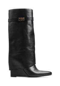 Czarne skórzane botki na koturnie z luźniejszą cholewą, z płaskim paskiem i metalowym akcentem. Spiczasty nosek z gładką powierzchnią.