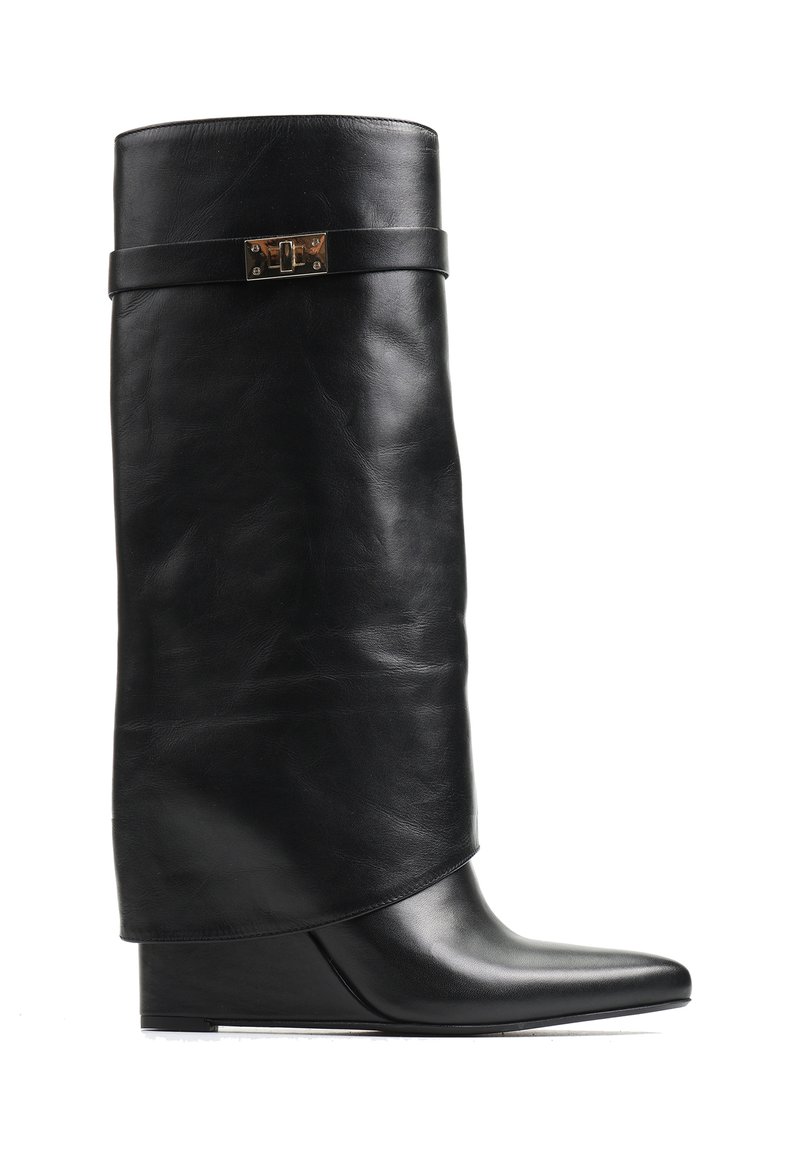 Czarne skórzane botki na koturnie z luźniejszą cholewą, z płaskim paskiem i metalowym akcentem. Spiczasty nosek z gładką powierzchnią.
