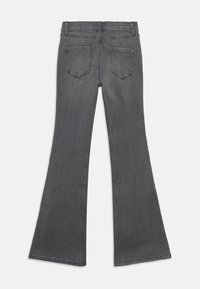 Γκρι καμπάνα τζιν, μέτρια πλύση, με μεσαία μέση, δύο πίσω τσέπες και λεία υφή. Καθαρές γραμμές, χωρίς πρόσθετες λεπτομέρειες.