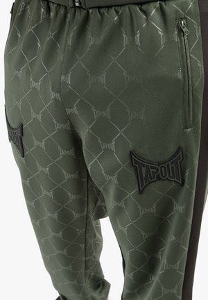 Rohelised sportlikud püksid, millel on kujundatud rombikiri "TAPOUT" brändingu, elastne vöökoht ja mustad detailid külgedel.