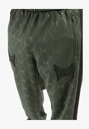 Grüne Sporthose mit einem Diamantmuster, "TAPOUT"-Markierung, elastischem Bund und schwarzen Akzenten an den Seiten.