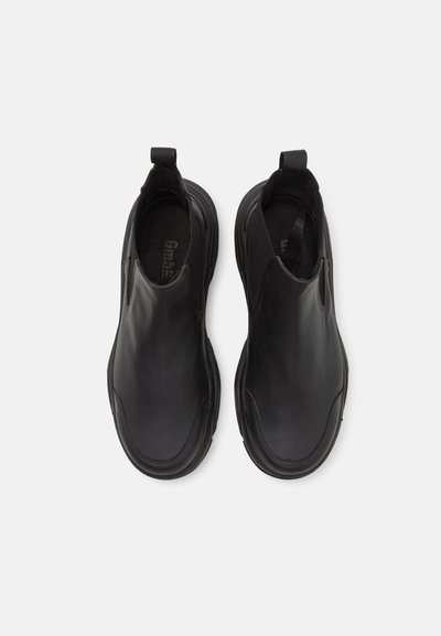 Svarta slip-on-skor i slätt läder, med elastiska sidopaneler och en rundad tåkonstruktion samt en texturerad innersula.