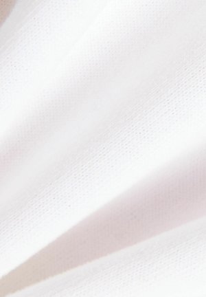 Nahaufnahme von weichem, sauberem weißen Stoff mit subtiler Textur und sanften Falten.