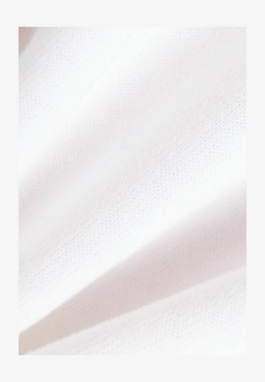 Nahaufnahme von weichem, sauberem weißen Stoff mit subtiler Textur und sanften Falten.