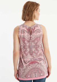 Mouwloze roze blouse met een paisleypatroon, stoffen strikdetail bij de hals en een gebogen zoom. Lichtgewicht, gladde textuur.