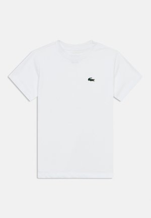 T-shirt blanc à manches courtes et col rond avec un petit logo de crocodile vert brodé sur la poitrine gauche.