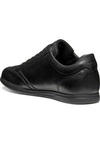 Sneaker in pelle nera con una texture liscia, punta arrotondata e suola in gomma a profilo basso. Presenta cuciture ton sur ton e un marchio discreto.