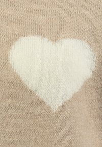 Pullover a maglia beige con un motivo a cuore crema sulla parte anteriore, che presenta una consistenza morbida con un leggero effetto sfumato.