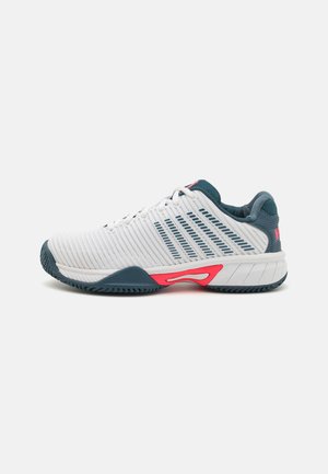 Weißer Sportschuh mit strukturiertem Obermaterial, blauen Akzenten und einer rosa Zwischensohle sowie einer flexiblen Gummisohle. Seitliche Ansicht gezeigt.