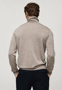 Beige tröja med hög krage, långa ärmar och perfekt passform i midjan. Slät textur, enkel design och ribbade muddar och fåll.