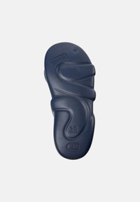 Tummansininen kumisaappaan pohja, jossa on aaltoileva muotoilu, muotoiltu ergonomisesti ja jossa on koon 38 leima, sileä pinta ja pyöreä koriste.