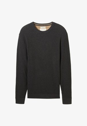 Pull noir à côtes avec un col rond et des manches longues. Tissu texturé et une étiquette visible au niveau du col.