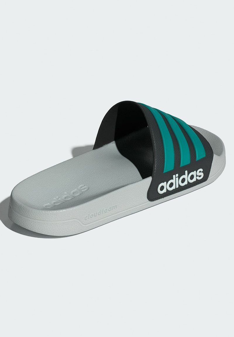 Adidas slidesandaler med en sort rem med teal accenter, grå tekstureret sål og Cloudfoam branding for komfort.