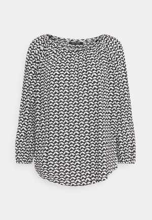 Blusa a maniche lunghe in bianco e nero con un motivo a foglia, scollatura rotonda e orlo arrotondato. Realizzata in tessuto leggero.