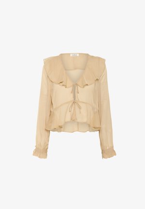 Blouse beige et légère avec un col volanté, décolleté en V profond, fermeture à nouer à l'avant et manches longues avec poignets volants pour un look superposé.