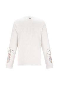 Witte langemouwen shirt met een getextureerde afwerking, voorzien van kleurrijke borduurontwerpen op beide mouwen en een ronde hals.