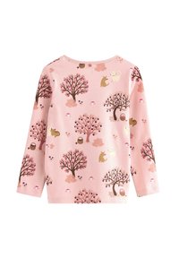 Roze overhemd met lange mouwen, bedrukt met bruine en roze bomen, kleine dieren, manden en champignons die over de stof verspreid zijn.