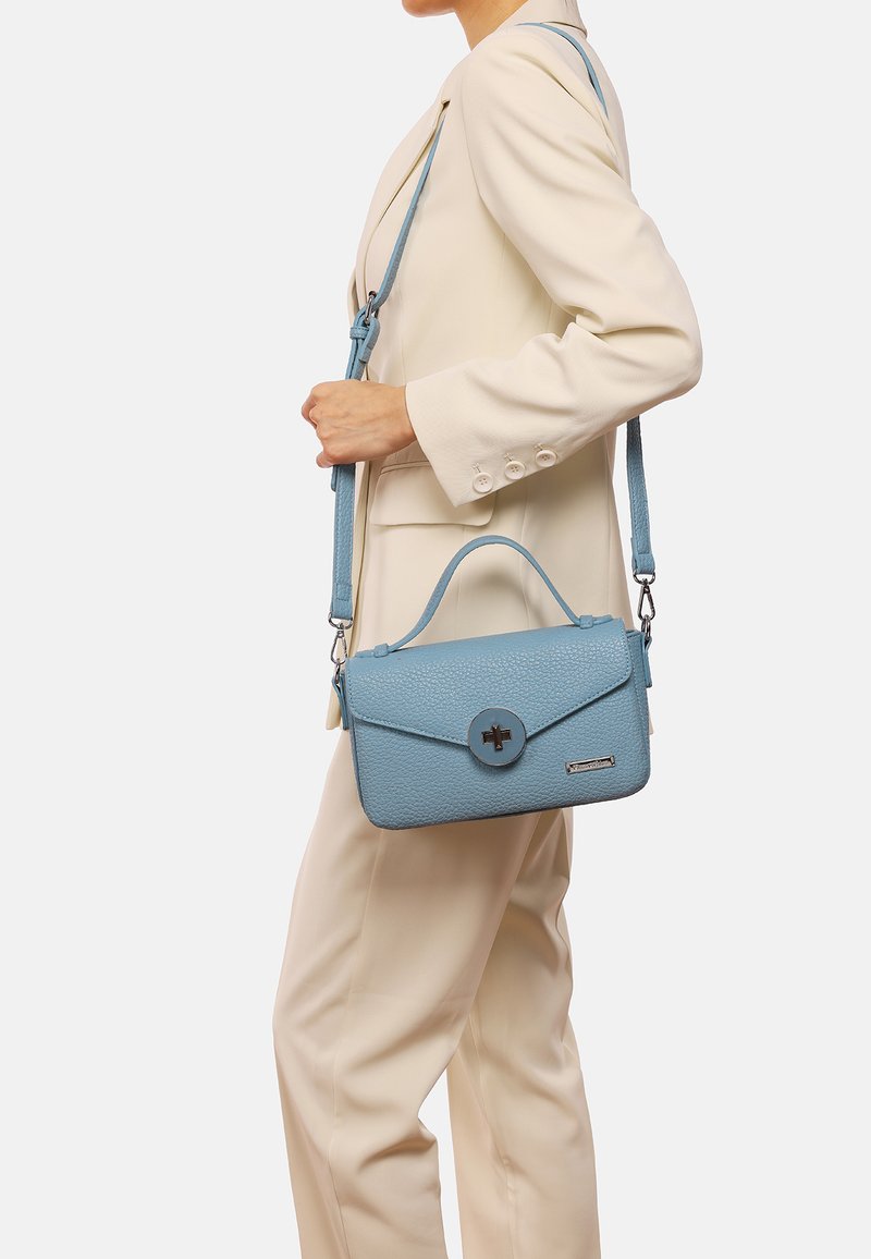 Borsa a tracolla in pelle blu con texture, dotata di manico superiore e spallaccio regolabile. Presenta una chiusura circolare e un design minimalista.