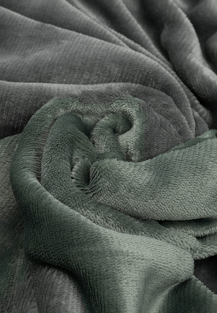 Couverture douce et moelleuse dans des nuances de gris foncé et de vert, présentant un tissu texturé et enroulé avec une finition lisse et sans motifs visibles.