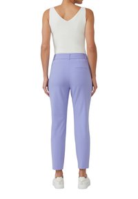 Hellviolette, maßgeschneiderte Hose mit glatter Textur, verfügt über eine Gesäßtasche und eine schmale Passform. Kombiniert mit einem weißen ärmellosen Oberteil und lässigen Sneakers.