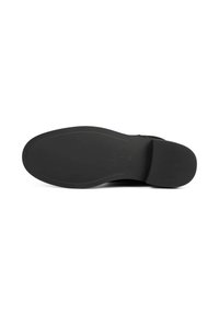 Semelle de chaussure en cuir noir présentant une texture lisse, une forme arrondie et des rainures subtiles. Talon rigide avec un dessous plat.