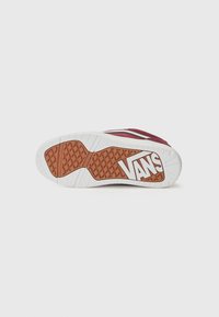 Red canvas sneaker sole with textured surface; side features white and brown accents with 'VANS' logo. Flat and durable design.
