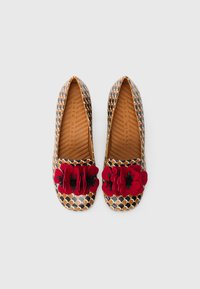 Mønstrede flade sko med et geometrisk design i brunt, guld og sort, med en fremtrædende rød blomst på tåen. Tekstureret indersål.
