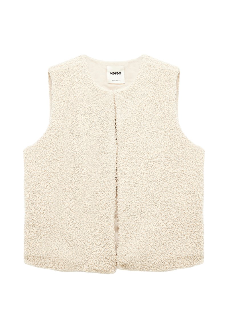 Kermavaiheessa oleva ilman hihoja oleva shearling-takki, jossa on pyöreä kaula-aukko ja auki oleva etuosa. Teksturoitu pehmeä fleece-kangas.