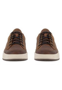 Brūnas ādas sporta kurpes ar melnām šņorēm, baltu vidējo zolīti un fakturētu gumijas ārpusi. Vienkāršs dizains ar minimālu detaļu daudzumu.