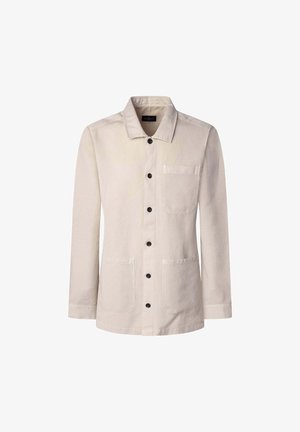 Jasnobeżowa kurtka wykonana z bawełny. Posiada wyrazisty kołnierz, zapięcie na guziki z przodu, dwie naszywane kieszenie oraz długie rękawy z guzikami przy mankietach.