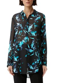 Blouse noire transparente avec un motif abstrait bleu et turquoise, fermeture boutonnée à l'avant, manches longues et ourlet légèrement arrondi.