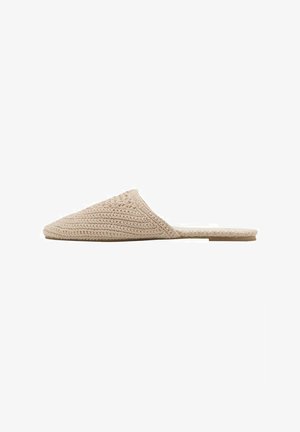 Scarpa slip-on in maglia beige con punta affusolata e suola piatta. Presenta un motivo testurizzato e un retro aperto per una facile calzata.