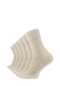 Calzini di cotone beige, con una texture a coste, un motivo sottile e lunghezza alla caviglia. Cinque paia esposti affiancati.