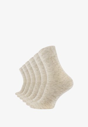 Chaussettes en coton beige, avec une texture côtelée, un motif subtil et une longueur chevilles. Cinq paires exposées côte à côte.