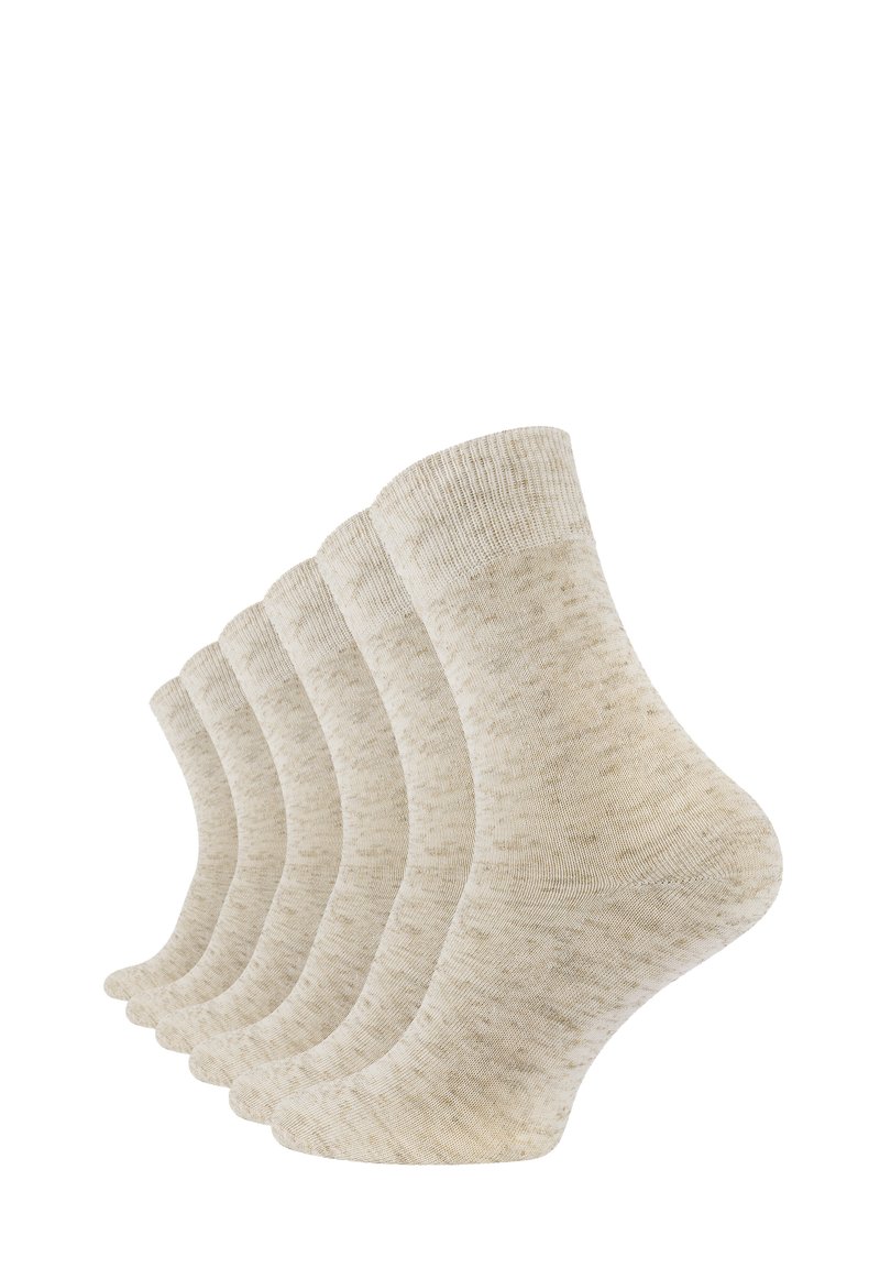 Calzini di cotone beige, con una texture a coste, un motivo sottile e lunghezza alla caviglia. Cinque paia esposti affiancati.