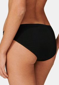 Zwarte katoenen bikinionderkant met een hoge uitsnijding. Kenmerkt naadloze randen en een gladde textuur, en toont een klassieke stijl.