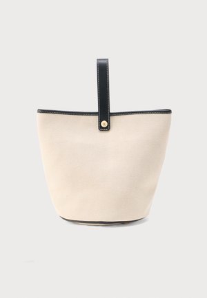 Beige stofspandtas med subtilt zigzagmønster, sort læderkant og en enkelt sort læderrem med en guldknap.